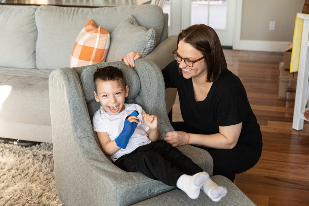 Angela smiles at Jack in the living room while Jack sits in a grey Chill-Out Chair.